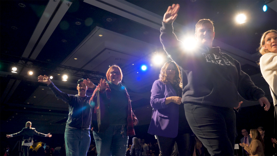 A close up of heroes strutting their stuff and waving on the runway from beside the runway at an upwards angle. 