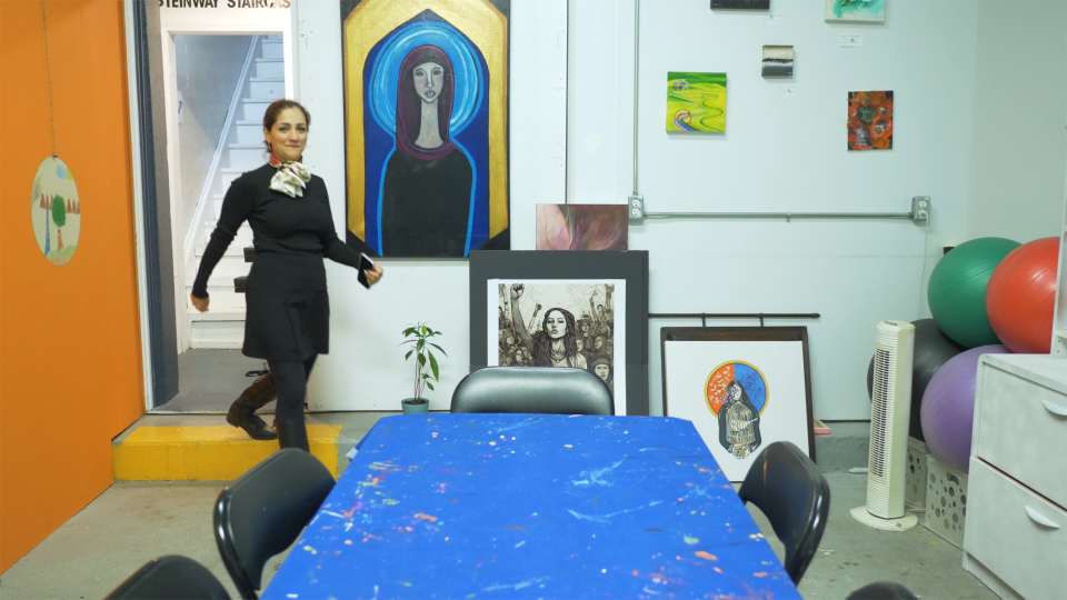 Video still of EPICentre student walking into room with a bunch of paintings on the walls